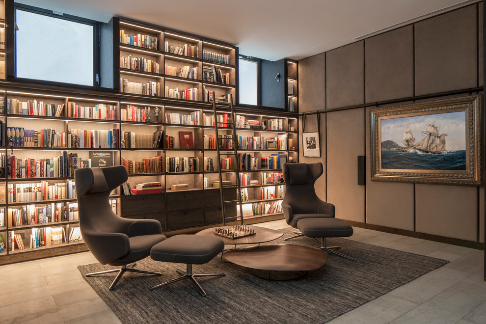 This is an example of a mid-sized modern home office in London with a library, grey walls and grey floor.