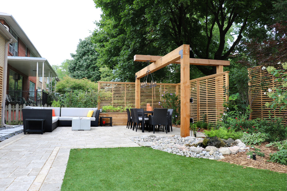 Design ideas for a large contemporary xeriscape in Toronto with with pond and concrete pavers.