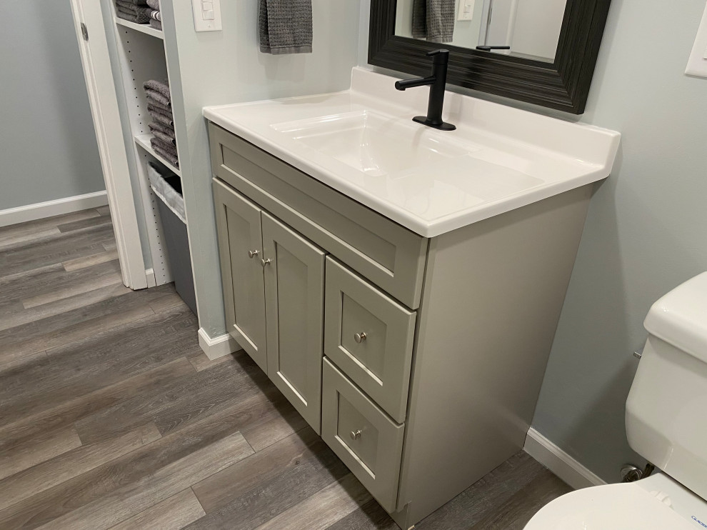 Large transitional l-shaped vinyl floor and gray floor open concept kitchen photo in Cincinnati with an undermount sink, raised-panel cabinets, white cabinets, granite countertops, multicolored backsplash, ceramic backsplash, stainless steel appliances, an island and black countertops