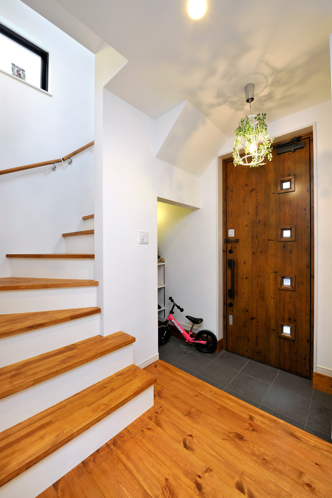 This is an example of a small asian entryway in Other with medium hardwood floors, a single front door and a dark wood front door.