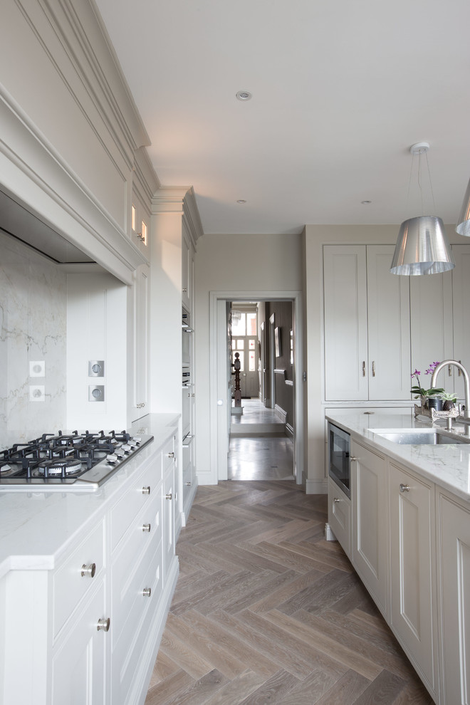 Design ideas for a contemporary L-shaped open plan kitchen in Dublin With Shaker Cabinets, Grey Cabinets, Marble Worktops, Stone Slab Splashback, Medium Hardwood Flooring and an Island.