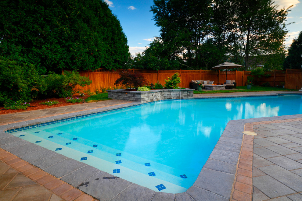 Design ideas for a mid-sized asian backyard l-shaped pool in Boston with a water feature and concrete pavers.