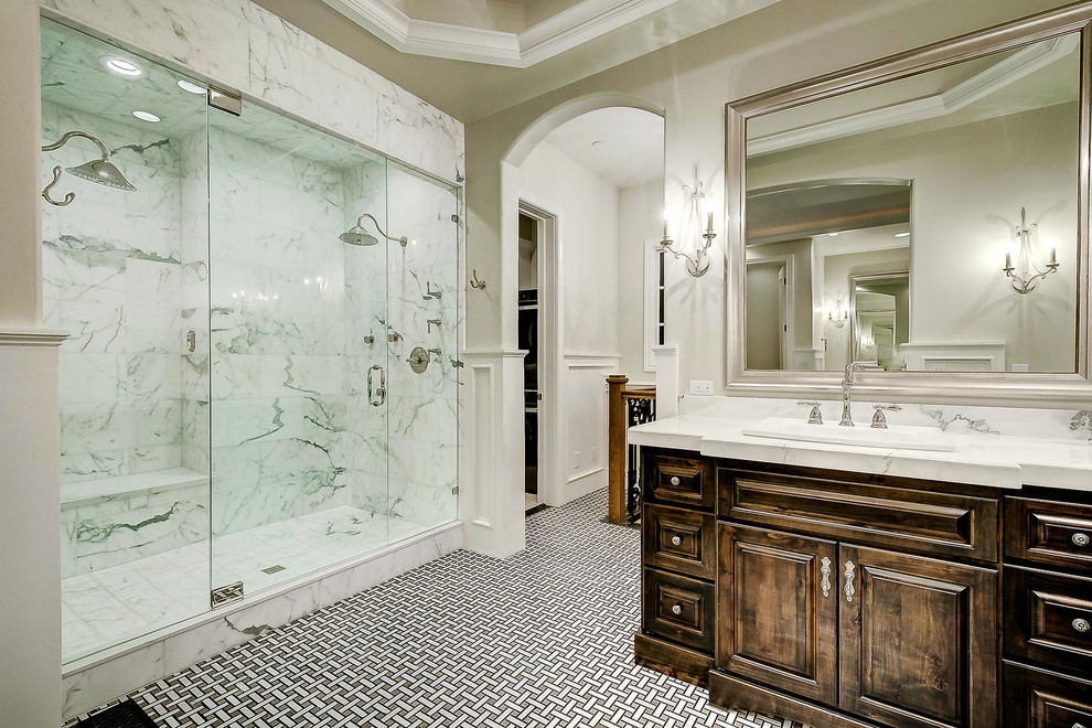 Expansive master bathroom in Denver with raised-panel cabinets, dark wood cabinets, a freestanding tub, an alcove shower, white walls, cement tiles, a drop-in sink, marble benchtops, multi-coloured floor, a hinged shower door and white benchtops.