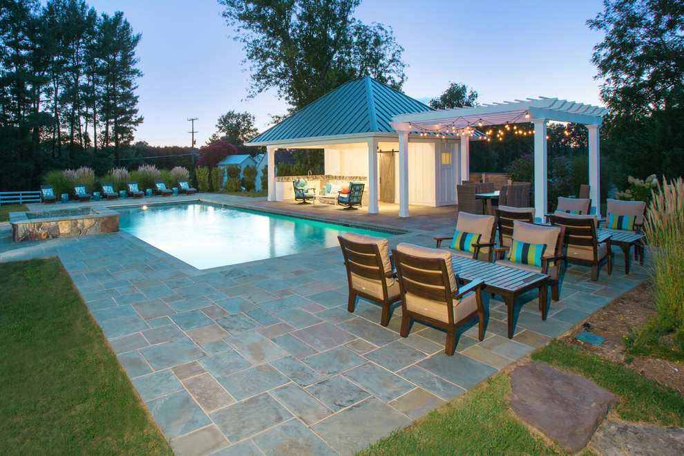 Design ideas for a large traditional backyard rectangular lap pool in DC Metro with a hot tub and natural stone pavers.