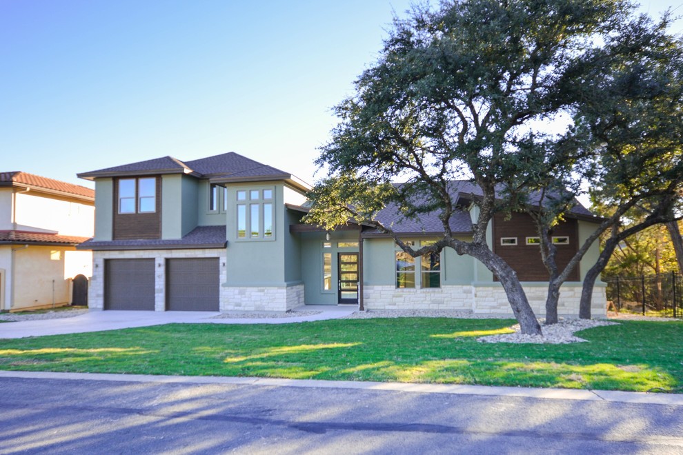 This is an example of a mid-sized contemporary two-storey green house exterior in Austin with mixed siding, a hip roof and a shingle roof.