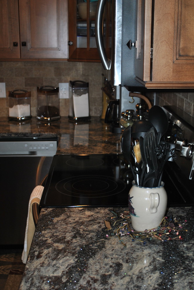 Inspiration for a brown floor kitchen remodel with brown cabinets, beige backsplash, stainless steel appliances, an island and gray countertops