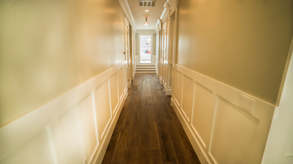 This is an example of a mid-sized traditional hallway in Salt Lake City with white walls, dark hardwood floors and brown floor.