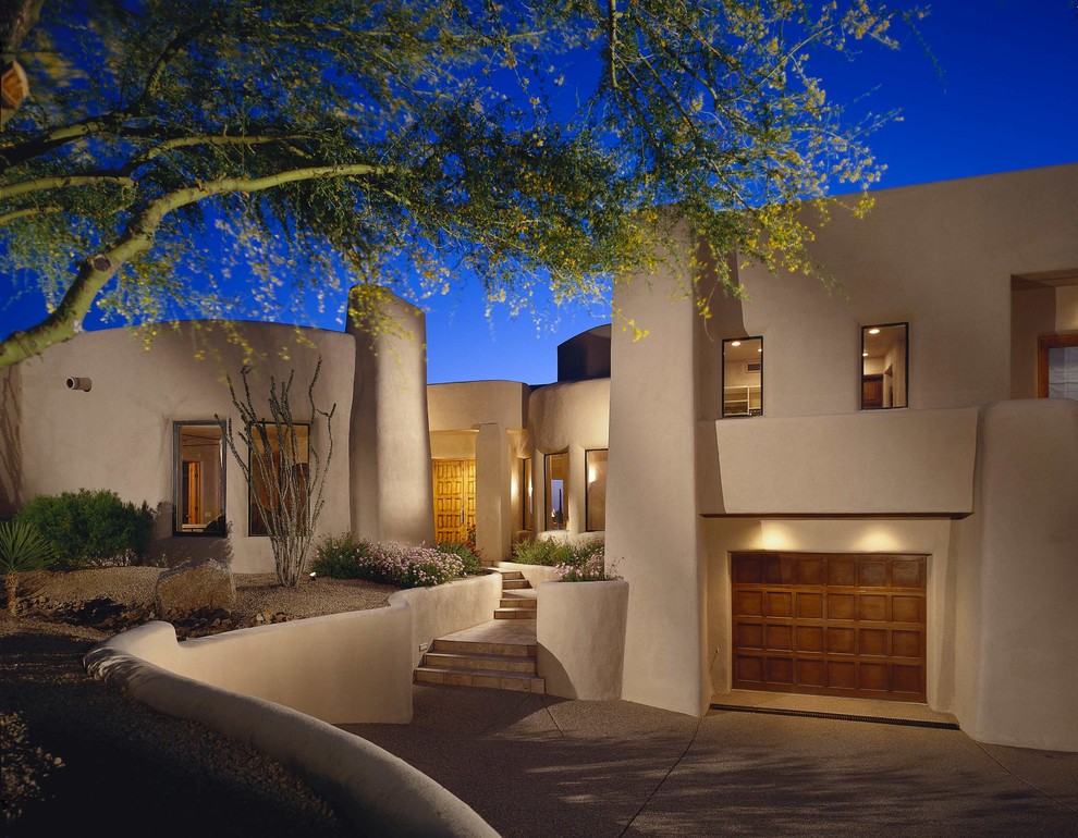 Inspiration for a two-storey adobe beige exterior in Phoenix.
