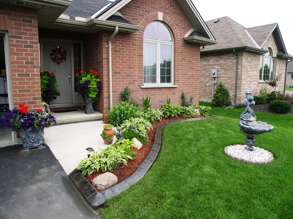 Inspiration for a traditional full sun garden for spring in Kansas City with concrete pavers.