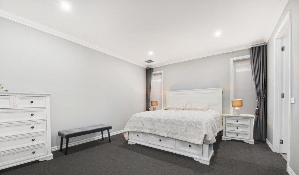 Large master bedroom in Melbourne with grey walls, carpet and black floor.