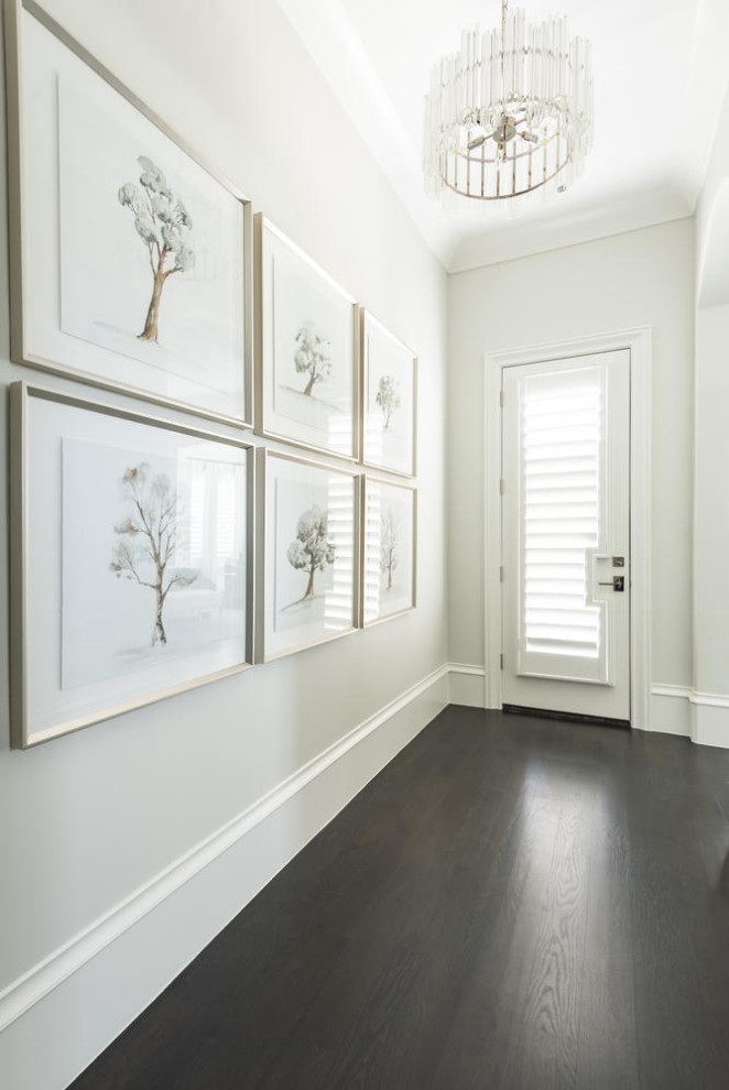 This is an example of a large mediterranean hallway in Dallas with white walls, dark hardwood floors and black floor.
