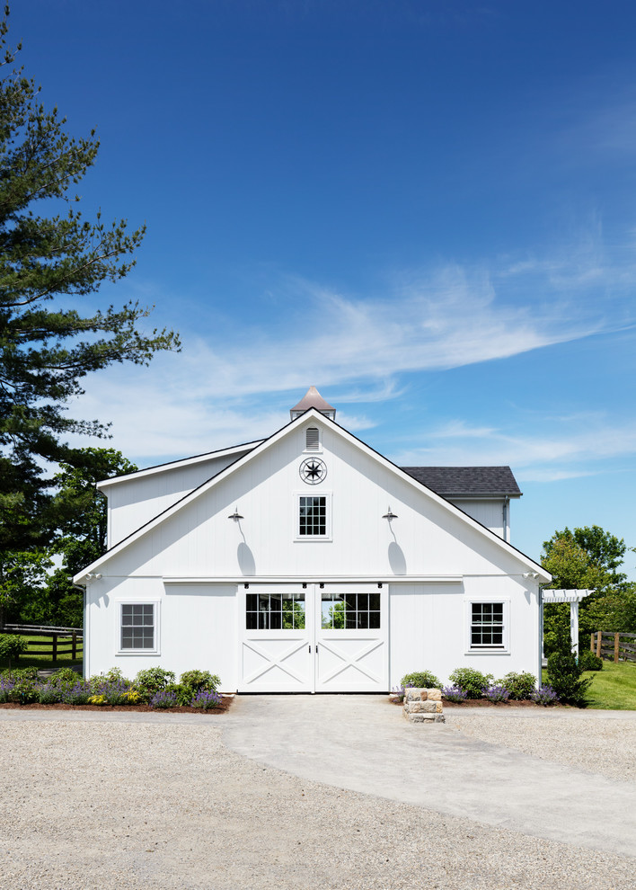 Country two-storey white house exterior in New York with a gable roof and a shingle roof.