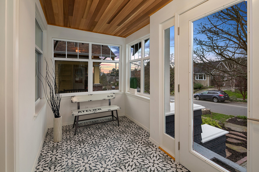 Photo of a transitional front yard screened-in verandah in Seattle with tile and a roof extension.