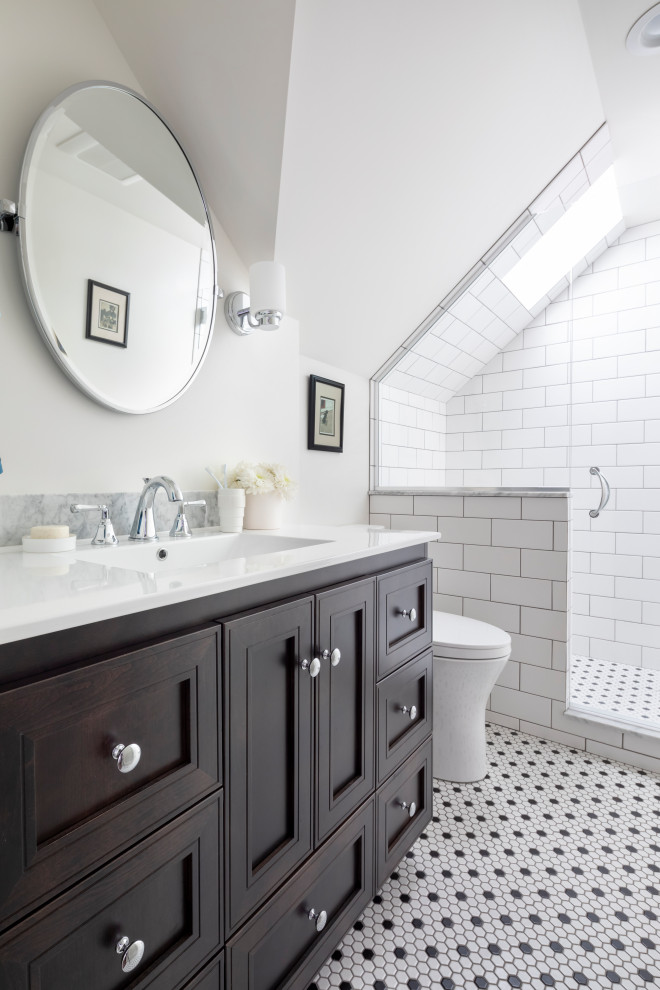 Bild på ett mellanstort vintage vit vitt badrum med dusch, med luckor med infälld panel, skåp i mörkt trä, en dusch i en alkov, en toalettstol med separat cisternkåpa, vit kakel, keramikplattor, vita väggar, klinkergolv i keramik, ett integrerad handfat, bänkskiva i akrylsten, vitt golv och dusch med gångjärnsdörr