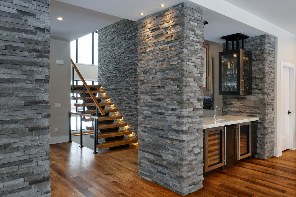 Inspiration for a contemporary wet bar in Cincinnati with an undermount sink, shaker cabinets, dark wood cabinets, quartzite benchtops, medium hardwood floors, brown floor and white benchtop.