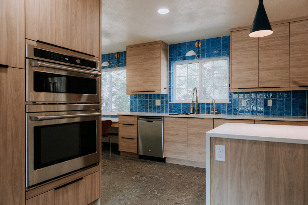 Inspiration for a large retro galley kitchen/diner in Albuquerque with a single-bowl sink, flat-panel cabinets, light wood cabinets, blue splashback, stainless steel appliances, an island, grey floors and white worktops.