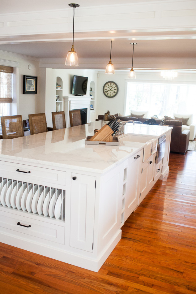 Eat-in kitchen - mid-sized transitional medium tone wood floor eat-in kitchen idea in St Louis with a farmhouse sink, flat-panel cabinets, white cabinets, white backsplash, subway tile backsplash, stainless steel appliances and an island