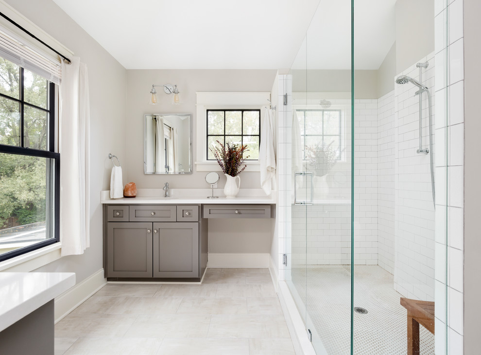 Design ideas for a transitional master bathroom in Charlotte with shaker cabinets, grey cabinets, white tile, subway tile, white walls, ceramic floors, an undermount sink, engineered quartz benchtops, grey floor, a hinged shower door, white benchtops and an alcove shower.