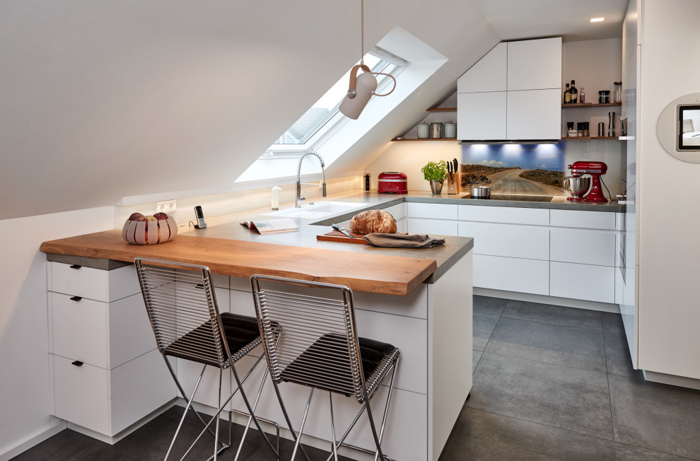 Design ideas for a mid-sized contemporary u-shaped eat-in kitchen in Dortmund with an undermount sink, flat-panel cabinets, white cabinets, tile benchtops, white splashback, glass sheet splashback, black appliances, ceramic floors, no island, green floor and grey benchtop.
