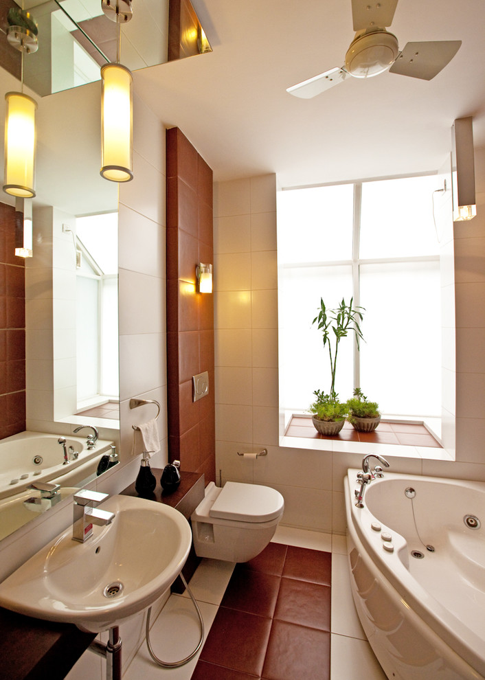 Inspiration for a small contemporary bathroom in Delhi with a corner tub, a wall-mount toilet, brown tile, white tile and a wall-mount sink.