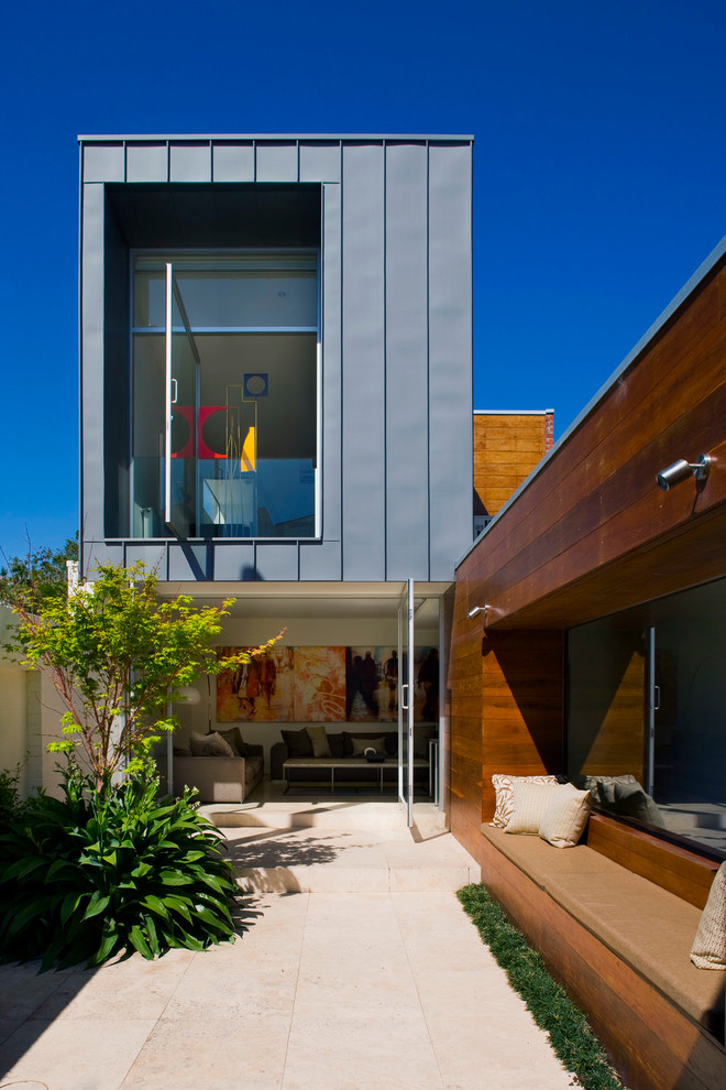 This is an example of a contemporary two-storey exterior in Melbourne with mixed siding and a flat roof.