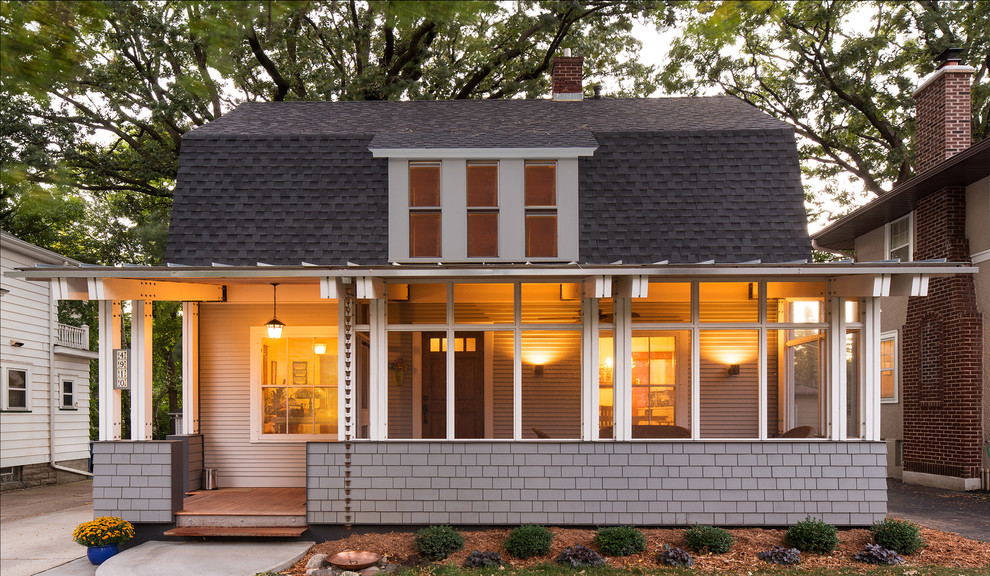 Inspiration for a traditional front yard screened-in verandah in Minneapolis with a roof extension.