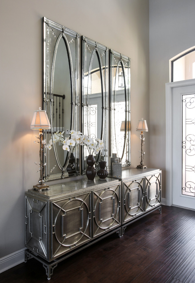 Example of a transitional dark wood floor foyer design in Miami with beige walls and a glass front door