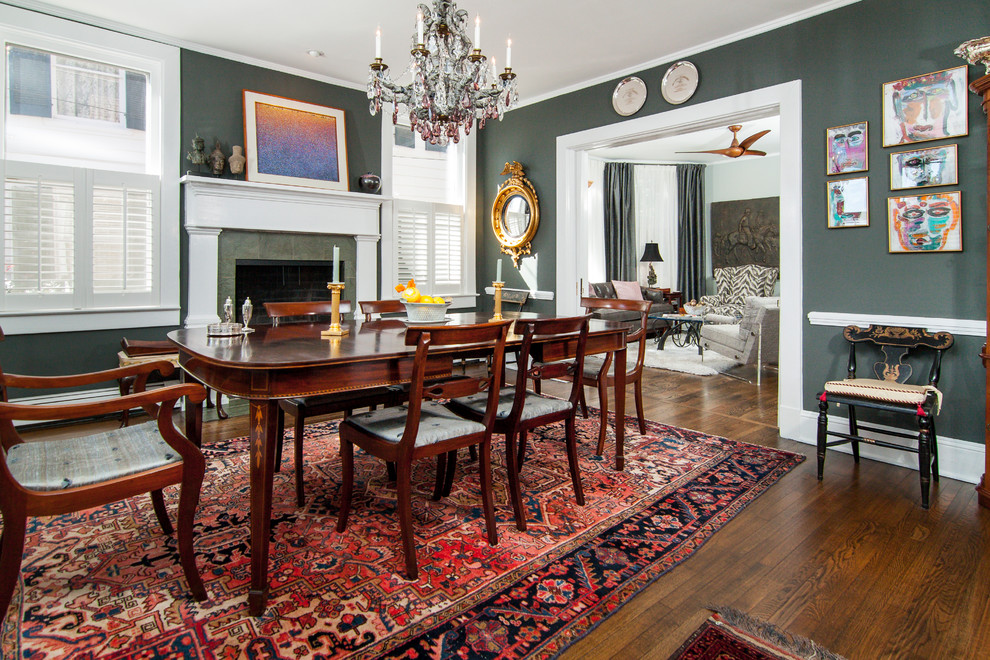Inspiration for a mid-sized eclectic separate dining room in Baltimore with grey walls, dark hardwood floors, a standard fireplace, a stone fireplace surround and brown floor.