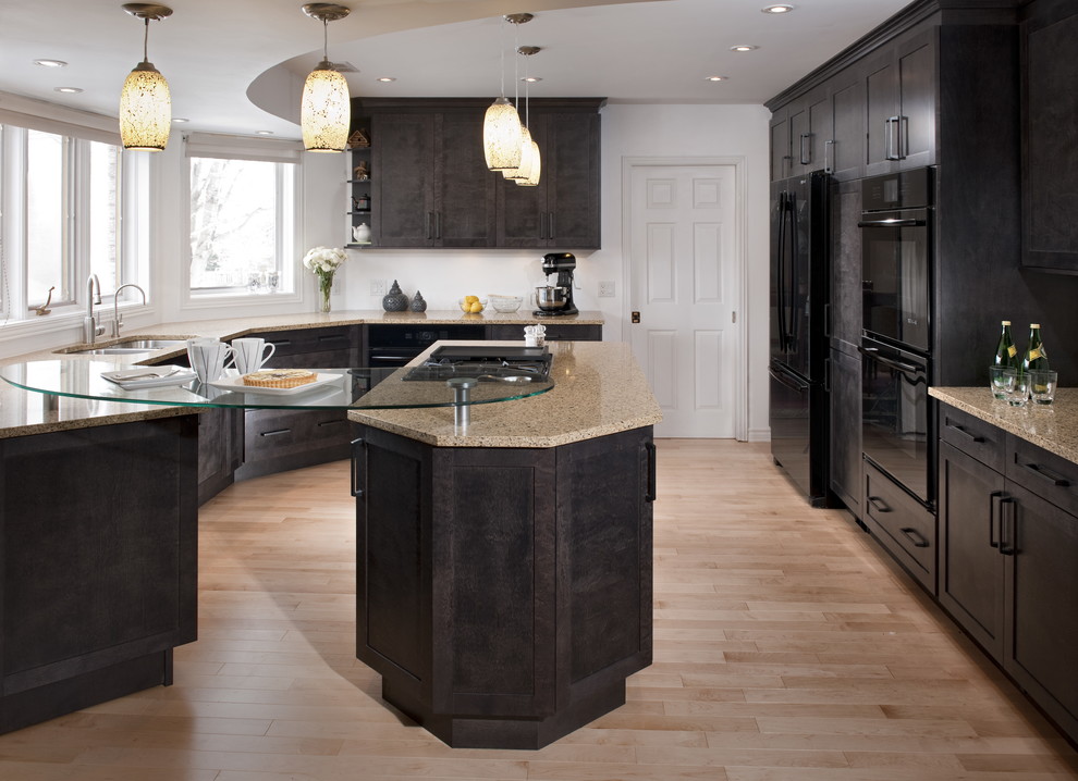 Inspiration for a mid-sized transitional u-shaped light wood floor eat-in kitchen remodel in Ottawa with shaker cabinets, dark wood cabinets, quartz countertops, black appliances, a peninsula and beige countertops