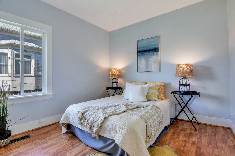Design ideas for a mid-sized arts and crafts master bedroom in Seattle with blue walls, light hardwood floors and brown floor.