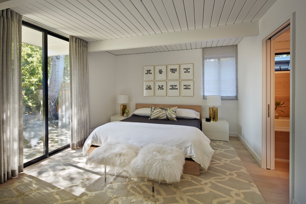 Midcentury master bedroom in San Francisco with white walls, light hardwood floors and no fireplace.