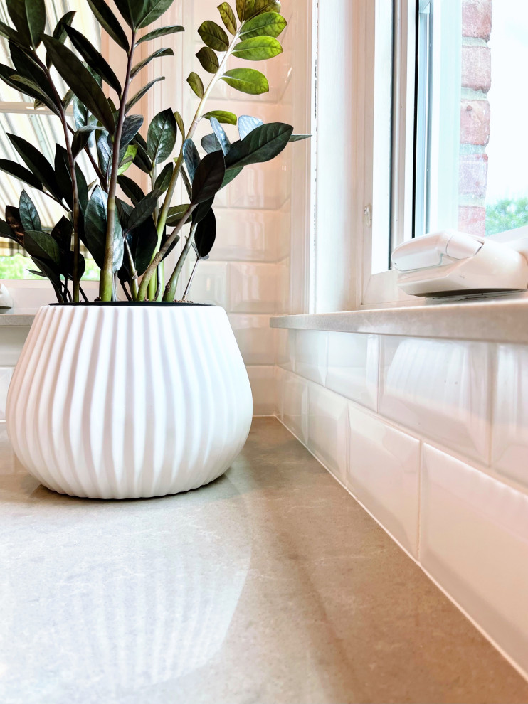Example of a large transitional u-shaped ceramic tile and beige floor open concept kitchen design with an undermount sink, recessed-panel cabinets, white cabinets, quartz countertops, white backsplash, ceramic backsplash, stainless steel appliances, an island and gray countertops