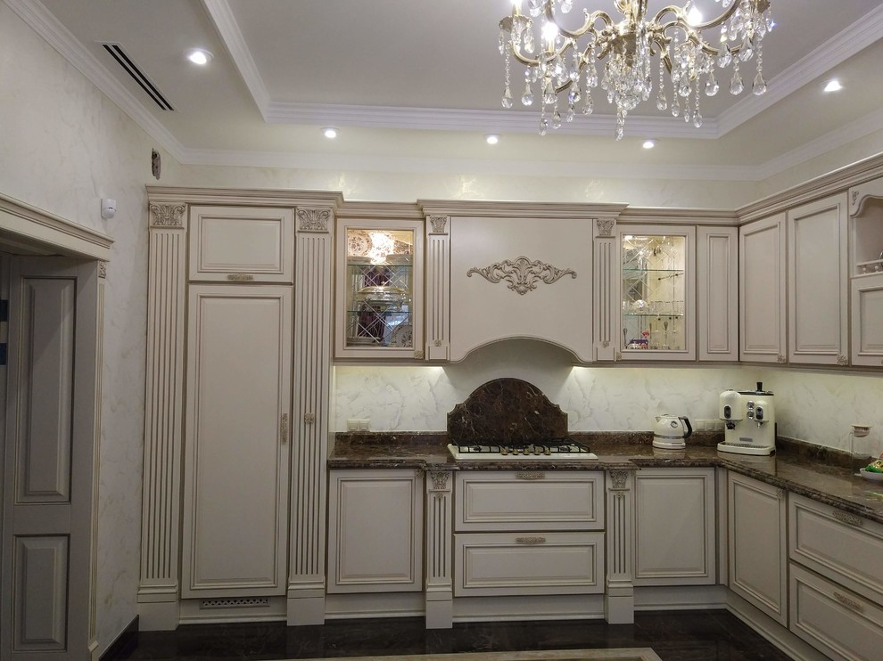 Traditional l-shaped eat-in kitchen in Other with an integrated sink, raised-panel cabinets, marble benchtops and no island.