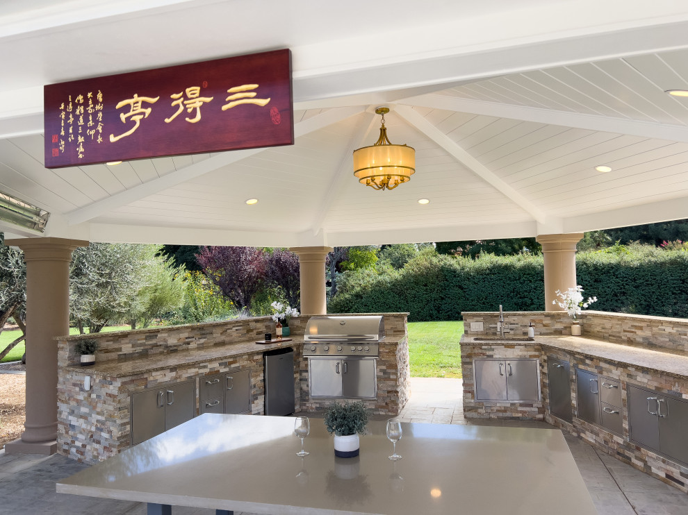 Photo of a large asian backyard patio in San Francisco with an outdoor kitchen, stamped concrete and a gazebo/cabana.