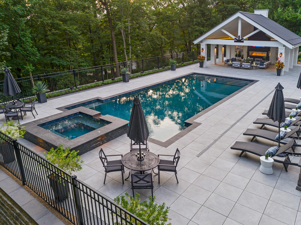 Inspiration for a large transitional backyard rectangular lap pool in Other with a pool house and concrete pavers.