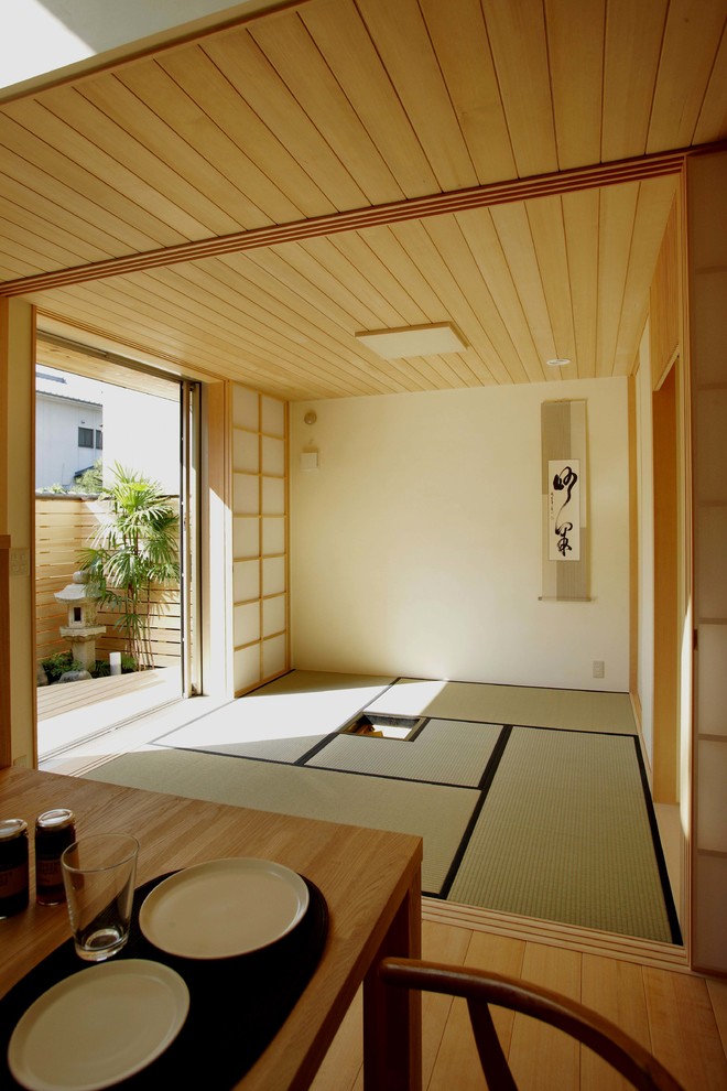 Asian enclosed living room in Kyoto with beige walls, no fireplace, no tv and tatami floors.