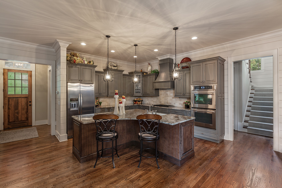 Eat-in kitchen - large l-shaped dark wood floor eat-in kitchen idea with a farmhouse sink, raised-panel cabinets, gray cabinets, granite countertops, multicolored backsplash, ceramic backsplash, stainless steel appliances and an island