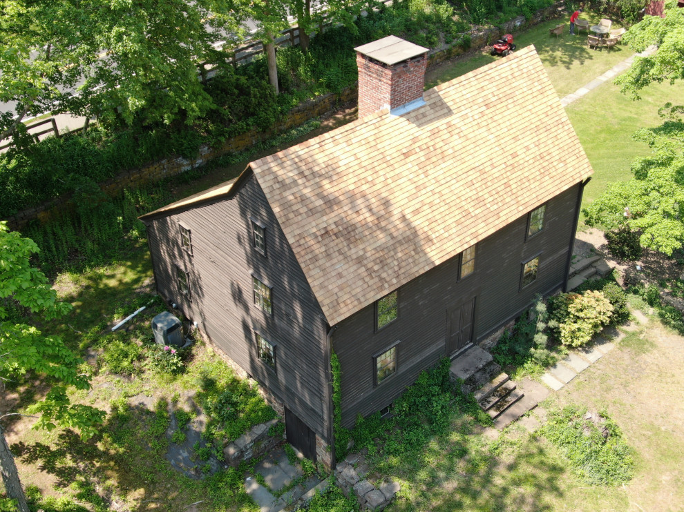 Foto de fachada de casa marrón y marrón clásica grande de tres plantas con revestimiento de madera, tejado a dos aguas, tejado de teja de madera y tablilla