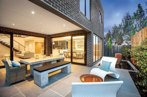 Large contemporary backyard patio in Melbourne with a fire feature, concrete pavers and a roof extension.