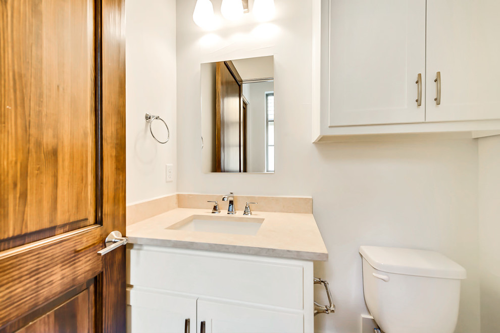 This is an example of a mid-sized transitional 3/4 bathroom in Dallas with shaker cabinets, white cabinets, a two-piece toilet, beige tile, beige walls, an undermount sink and engineered quartz benchtops.