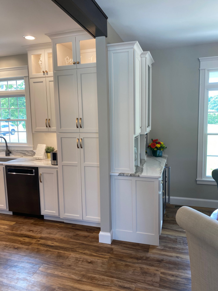 Open concept kitchen - large transitional l-shaped medium tone wood floor and brown floor open concept kitchen idea with an undermount sink, flat-panel cabinets, white cabinets, quartz countertops, multicolored backsplash, quartz backsplash, black appliances, an island and multicolored countertops