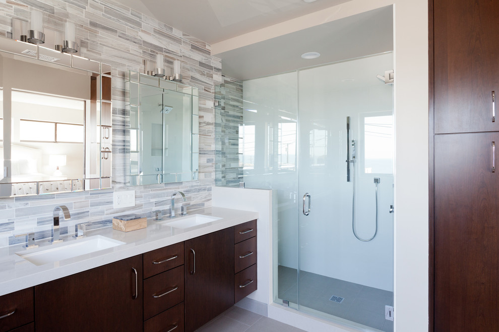 This is an example of a mid-sized contemporary master bathroom in Los Angeles with shaker cabinets, dark wood cabinets, a freestanding tub, a corner shower, a one-piece toilet, beige tile, porcelain tile, white walls, porcelain floors, an undermount sink and engineered quartz benchtops.