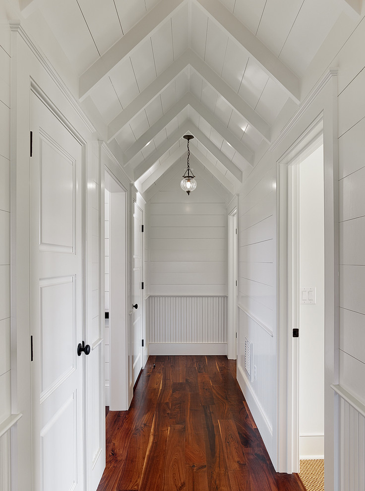 Design ideas for a traditional hallway in Charleston with white walls, dark hardwood floors and brown floor.