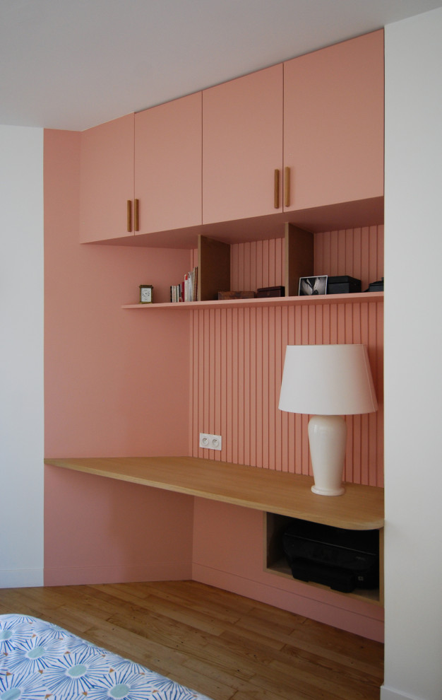 Design ideas for a small contemporary study room in Paris with pink walls, medium hardwood floors, a built-in desk, beige floor and decorative wall panelling.