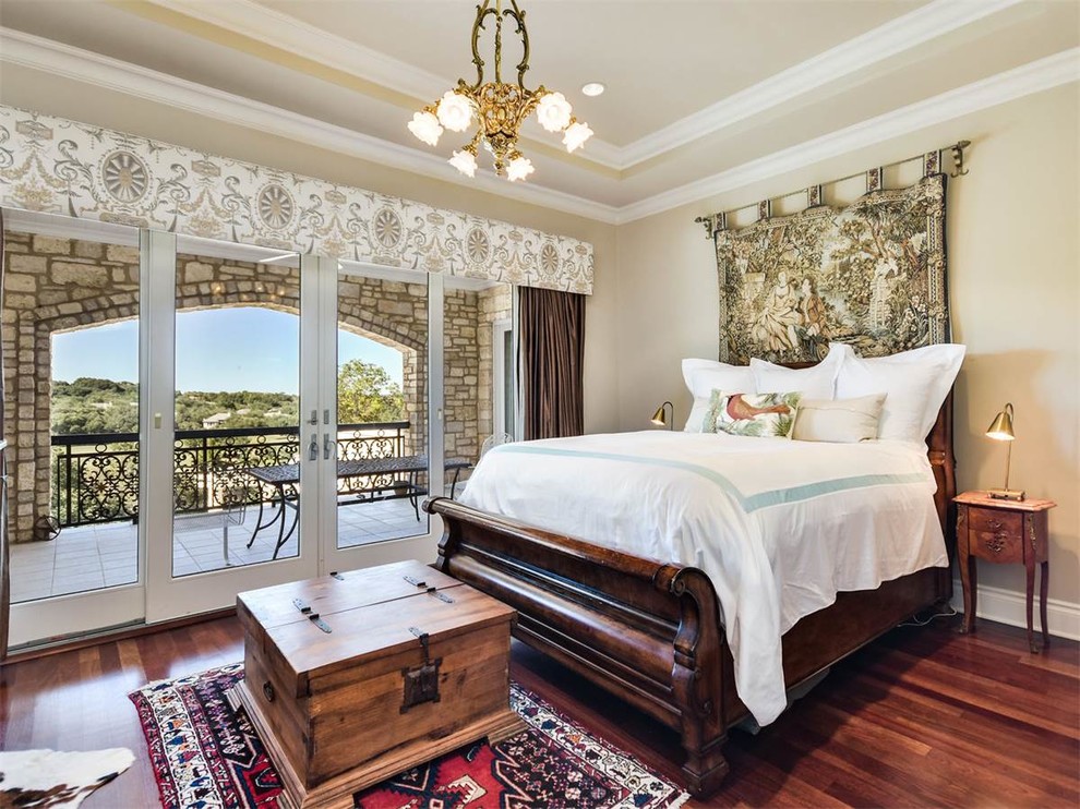 Mid-sized traditional guest bedroom in Austin with beige walls, medium hardwood floors and brown floor.