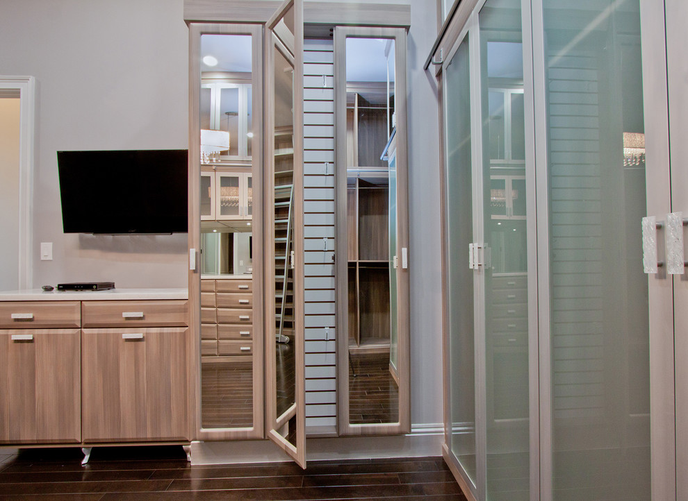 This is an example of an expansive transitional women's walk-in wardrobe in Miami with raised-panel cabinets, dark wood cabinets and dark hardwood floors.