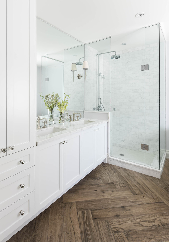 Inspiration for a traditional bathroom in Toronto with an undermount sink, shaker cabinets, white cabinets, a corner shower, white tile and dark hardwood floors.
