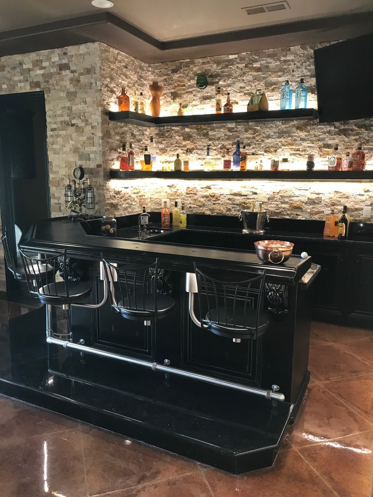Design ideas for a mid-sized industrial u-shaped seated home bar in Other with brown splashback, stone tile splashback, concrete floors, brown floor and black benchtop.