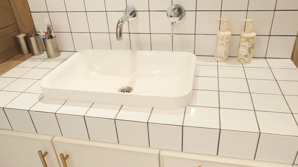 Photo of a small contemporary ensuite bathroom in Barcelona with open cabinets, beige cabinets, an alcove bath, a shower/bath combination, white tiles, ceramic tiles, white walls, ceramic flooring, a console sink, tiled worktops, white floors, a shower curtain, beige worktops, an enclosed toilet, a single sink, a built in vanity unit and a vaulted ceiling.