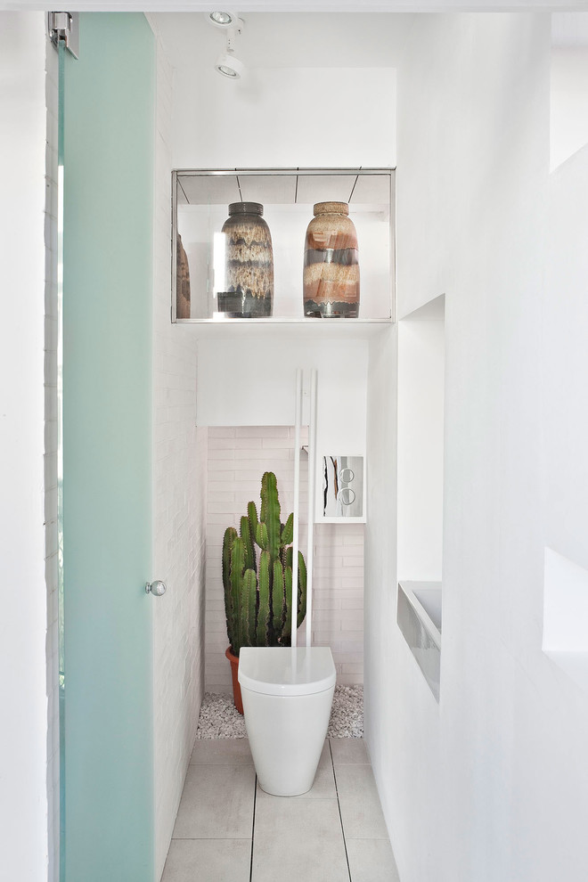 Photo of a small scandinavian powder room in Madrid with a one-piece toilet, white walls and cement tile.